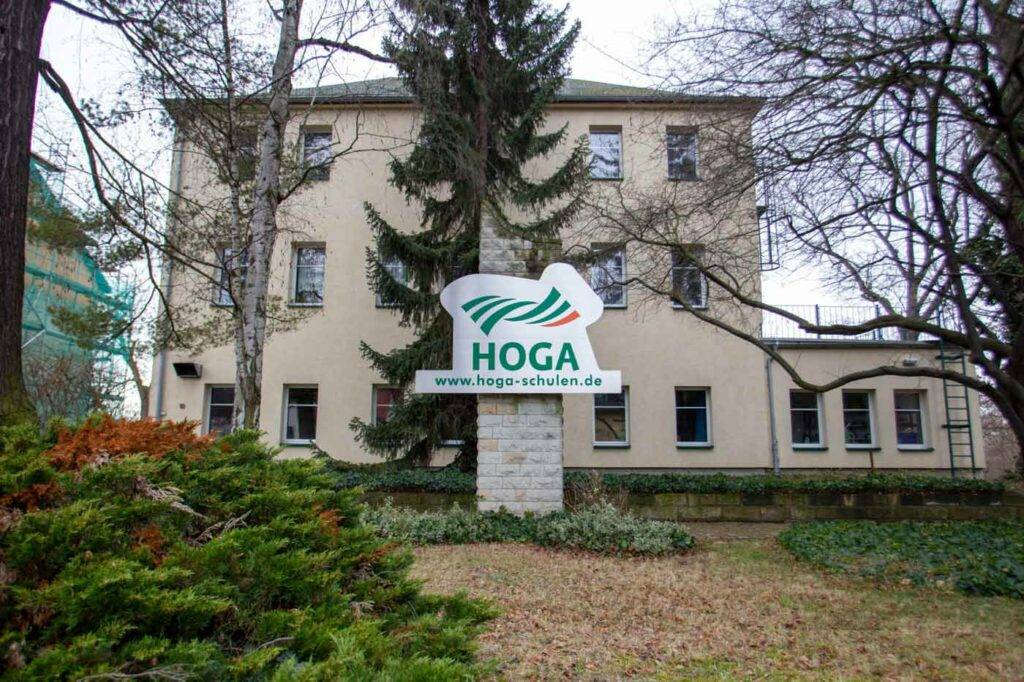 Ansicht eines HOGA Schulgebäudes in Dresden Tolkewitz mit Logo im Vordergrund