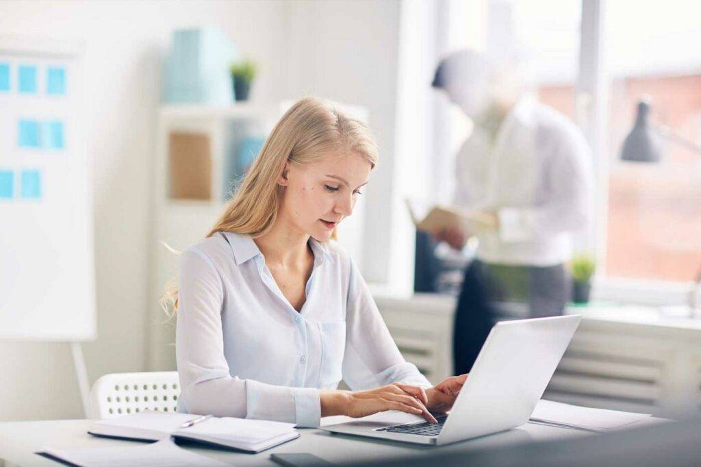 Mitarbeiterin arbeitet am Laptop in der Verwaltung der HOGA Schulen Dresden