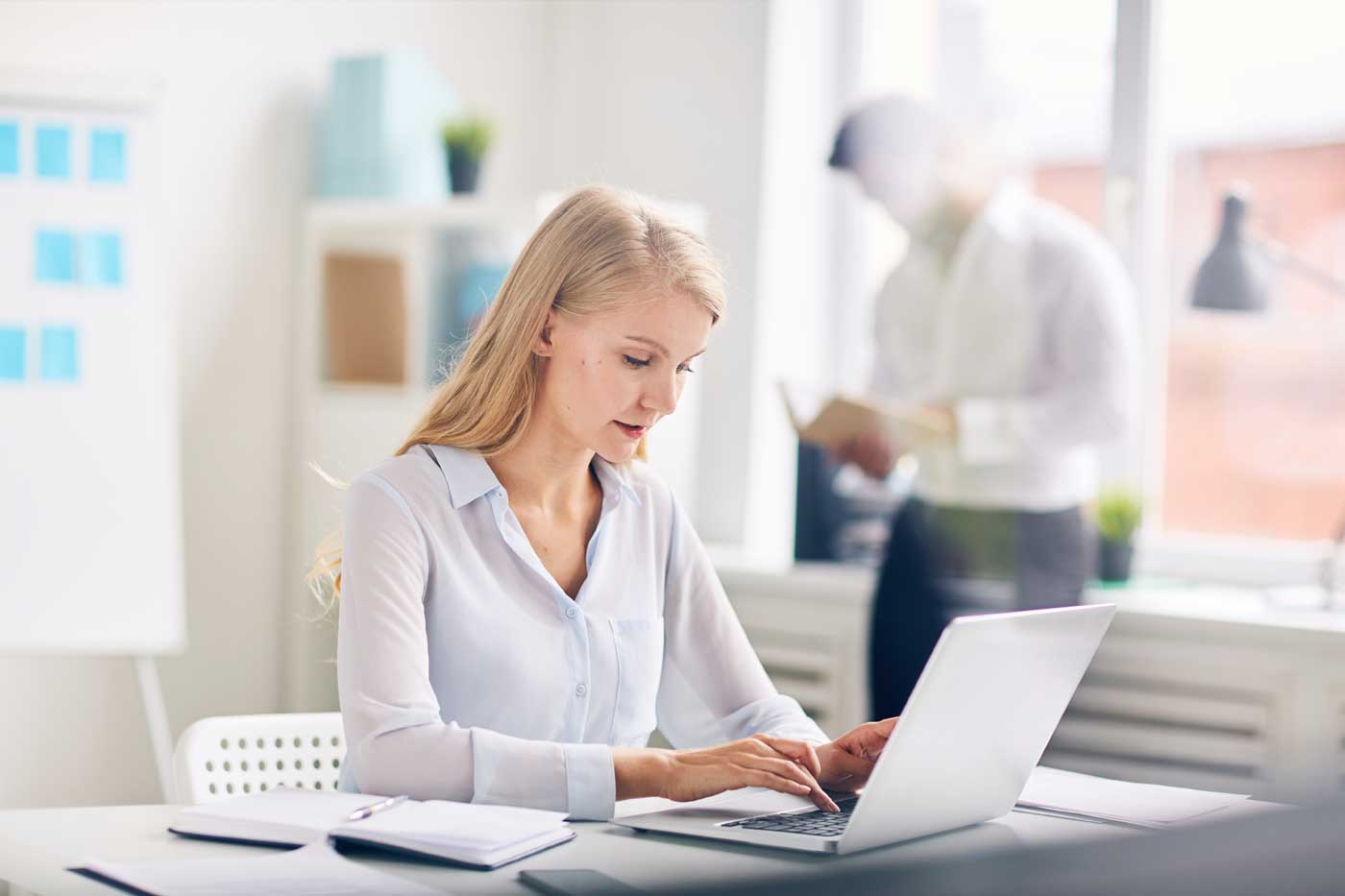 Mitarbeiterin arbeitet am Laptop in der Verwaltung der HOGA Schulen Dresden