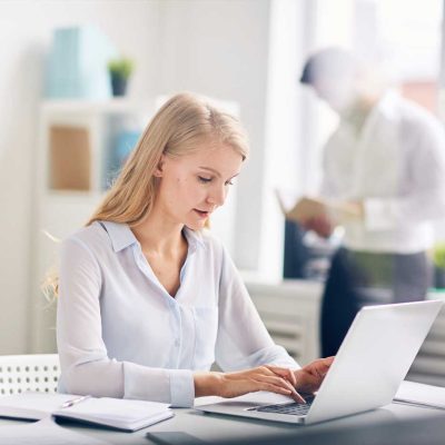 Mitarbeiterin arbeitet am Laptop in der Verwaltung der HOGA Schulen Dresden